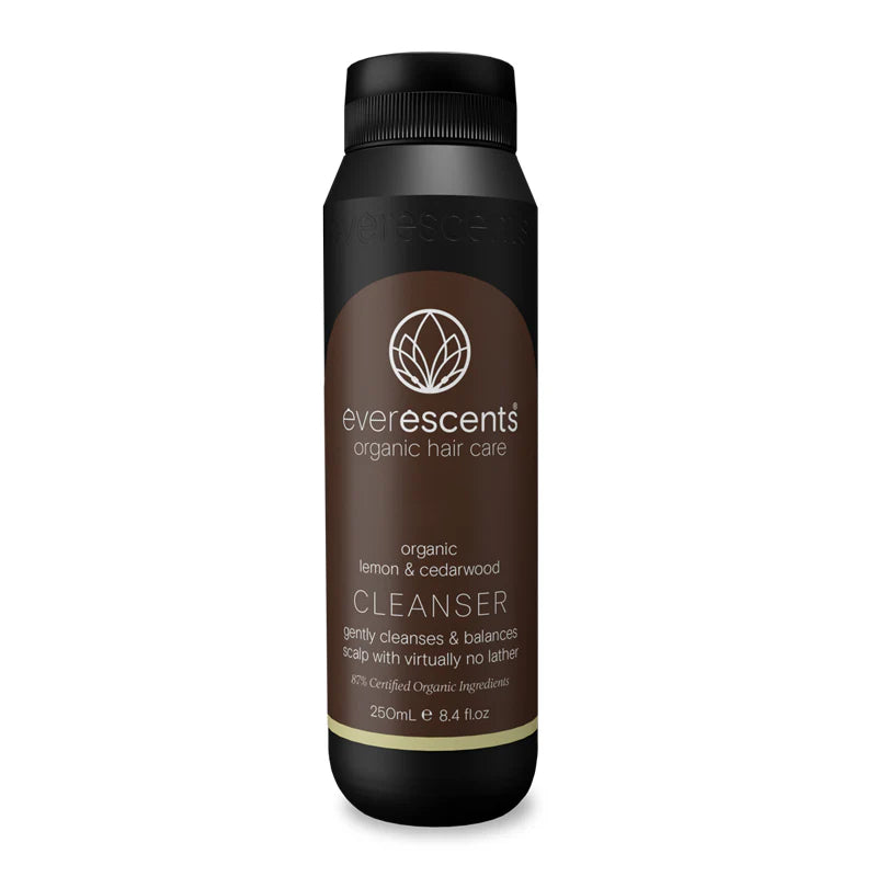 EverEscents Lemon & Sandalwood Cleanser bottle showing the label and product packaging in a natural setting.
